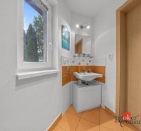 A bathroom with orange tiles, a sink, and a window, the cabin offers a compact space.
