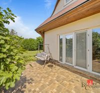 Terrace of a cottage in Vojka nad Dunajom with a swing and greenery in the background.