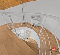 A spiral staircase and a wooden-decor floor in a cabin.