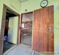 The interior of the cabin features wooden doors, a clock, and a tiled floor.