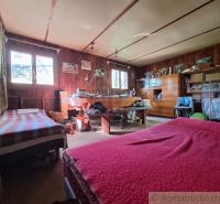 A spacious room in a cabin with two beds, wooden decor, and storage spaces.