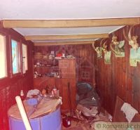 The interior of a cabin with wooden decor, a shelf, and trophies on the wall.