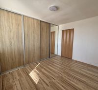 A room in a 3-room apartment with a wooden decor floor and a built-in wardrobe.