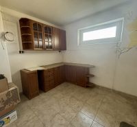 A kitchen unit in a 3-room apartment with a floral pattern on the wall, tiled floor.