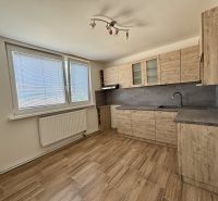 A kitchen in a 3-room apartment with a wooden decor floor and large windows.