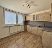 A kitchen with a wooden decor in a 3-room apartment with a large window and a bright space.