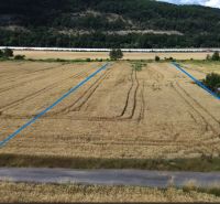 Lands - living Stožok with a field, house, and car, surrounded by forests and mountains.