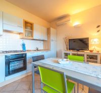 A kitchen in a holiday apartment with a dining table and modern appliances.
