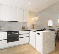 A kitchen in a 3-room apartment with white cabinets and a wooden decor floor.