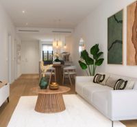A bright living room in a three-room apartment with a wooden decor floor and stylish furniture.