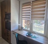 A kitchen in a 3-room apartment with a dining counter, Christmas blinds, and marble flooring.