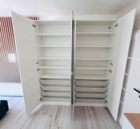 White built-in wardrobe with open doors and a wooden decor floor in a 3-room apartment.