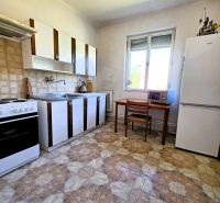 A kitchen in a family house with tiled flooring and furniture in a wooden decor.