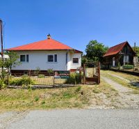 A family house in Slanská Huta with a red roof, fenced, and next to an older house.