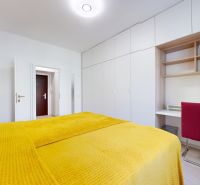 Bedroom in a two-room apartment with a bed and a built-in wardrobe, floor with wood decor.