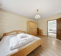 Bedroom in a holiday apartment with a bed, wardrobe, and wooden decor flooring.