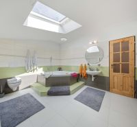 Bathroom with a bathtub, skylight, sink, and modern tiles in a Holiday Apartment.