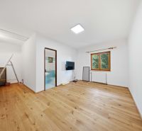 Living room with wood-patterned flooring and a view in a holiday apartment.