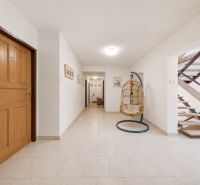 Hallway in a recreational apartment with a chair and staircase.