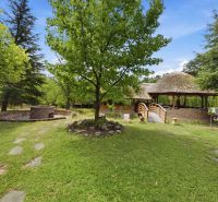 Recreational apartment in Trnava with a wooden bridge, grill, and greenery.