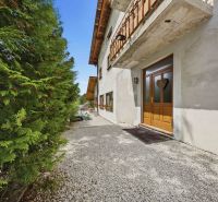 Entrance to a recreational apartment in Trnava with a landscaped stone pathway and greenery.
