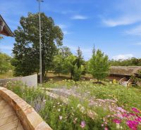 The garden of the recreational apartment in Trnava with a flower bed and trees.