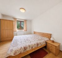 Bedroom in a holiday apartment with a bed, wardrobe, and wooden decor flooring.