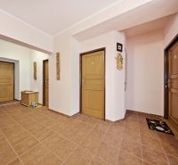 Interior of a holiday apartment with brown doors and ceramic tiles on the floor.