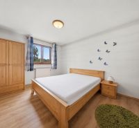 Bedroom in a holiday apartment with wood-decor flooring and wooden furniture.