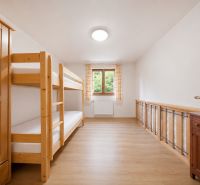 A room in a holiday apartment with a bunk bed and a wooden decor floor.