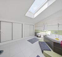 Spacious bathroom with a bathtub in the Holiday Apartment, bright and minimalist atmosphere.