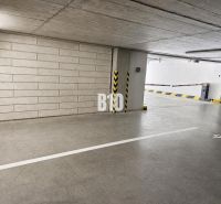 A parking lot in garages, clean concrete walls, and lighting complement the lines on the floor.