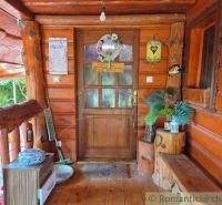 Entrance to a family house with wooden decor in Lehota, adorned with plants and signs.