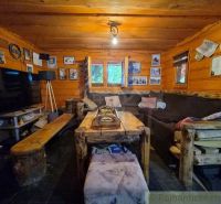 A rustic interior of a living room in a family house with wooden ceilings and furniture.