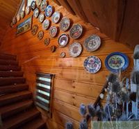 Wooden interior with decorative plates on the wall, staircase, decorations.