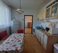 A kitchen in a 3-room apartment with a dining area and a wooden decor floor.
