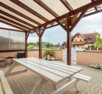 A terrace with a table at a 2-room apartment in Poprad, with a covered seating area.