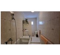 A family house bathroom with a bathtub, sink, and tiles, a distinctive feature of the tiling.