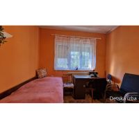 Children's room with a desk, bed, and window, floor with wooden decor, family house.
