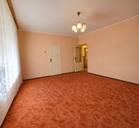 Living room with an orange carpet, white ceiling, and curtain in a family house.