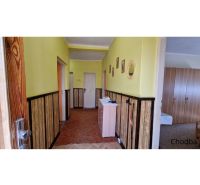A hallway in a family house with yellow walls and wooden paneling.