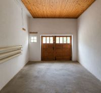 Empty garage in a family house with a wooden ceiling and large doors.