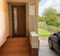The entrance staircase of a family house on Gardom Street in Veľký Šariš, with a parked car next to it.