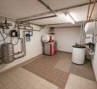 Boiler room in a family house with equipment and tiles in neutral tones.