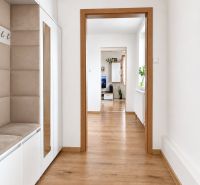 A hallway with a wooden decor floor in a family house, with access to the living room.