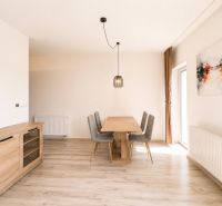 Dining room in a 3-room apartment with a wooden decor floor and simple furniture.