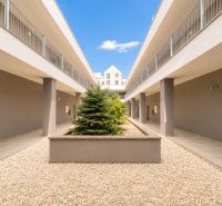 Entrance courtyard of a 3-room apartment in Liptovský Mikuláš with greenery and gravel surface.
