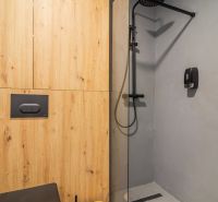 Bathroom in a holiday apartment with wood-effect flooring and a shower enclosure.