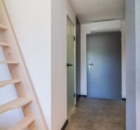 Hallway of a recreational apartment with wooden stairs and doors.