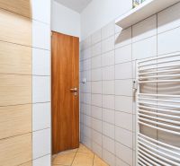 A bathroom with tiles and a white radiator in a 3-room apartment.